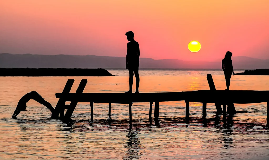 Güneşin Çocukları fotoğrafı - Gün batımında iskelede oynayan çocukların siluetleri